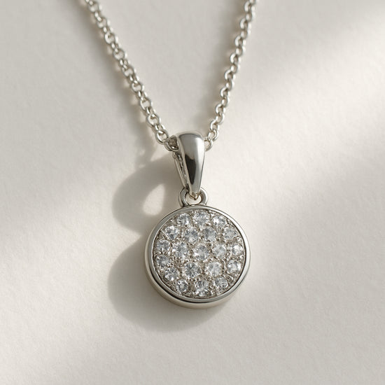 A close‑up of a sterling‑silver pave pendant necklace resting on a minimalist white background, with a soft natural light highlighting the facets. Alt: Pave pendant necklace sparkle